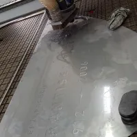 Gravírování písmen do masivní nerezové desky o rozměru 1,8 x 1 m pro památník Jaroslava Fajtla